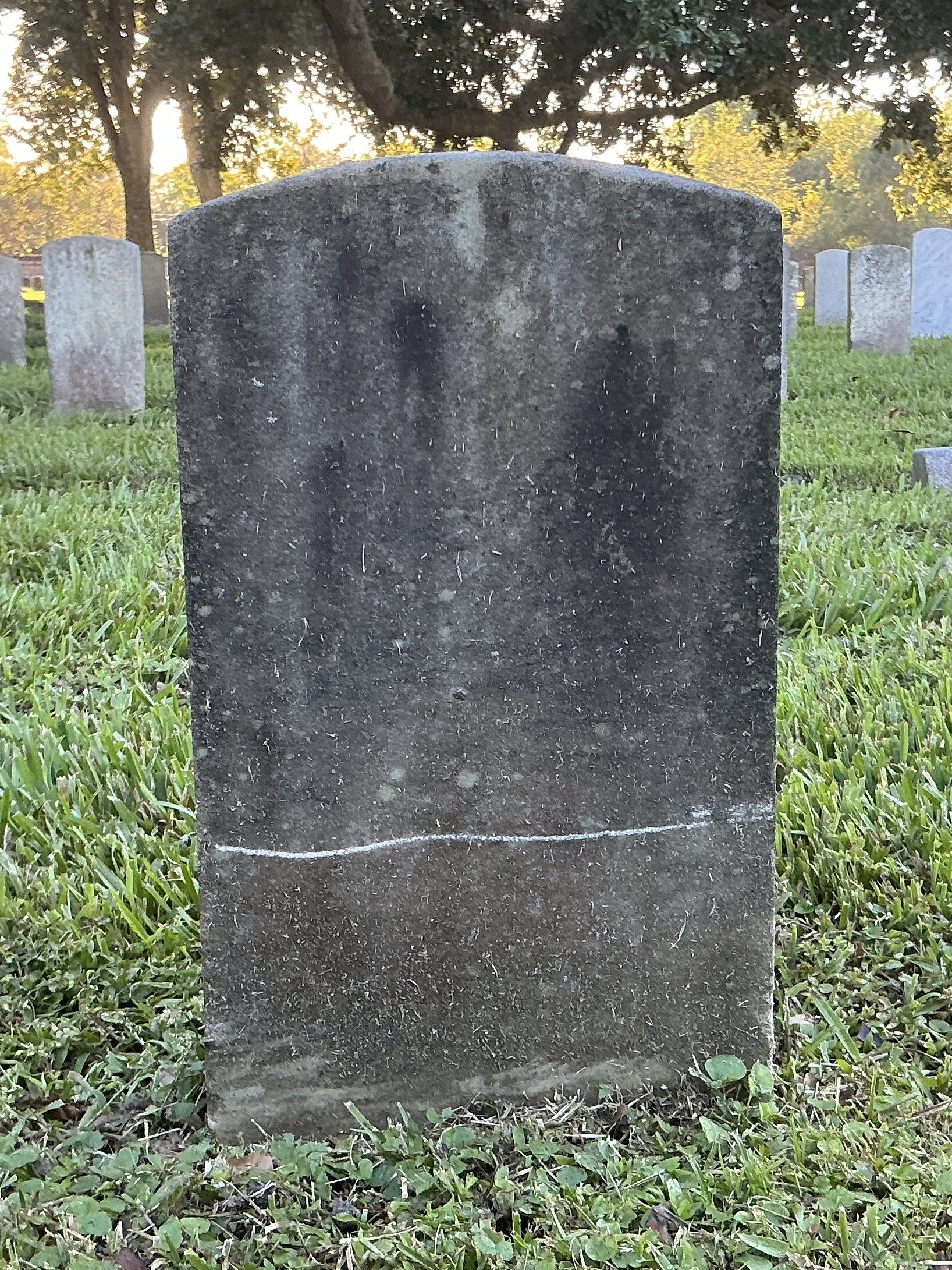 Back of historic upright marble headstone with recessed shield with recessed lettering face.