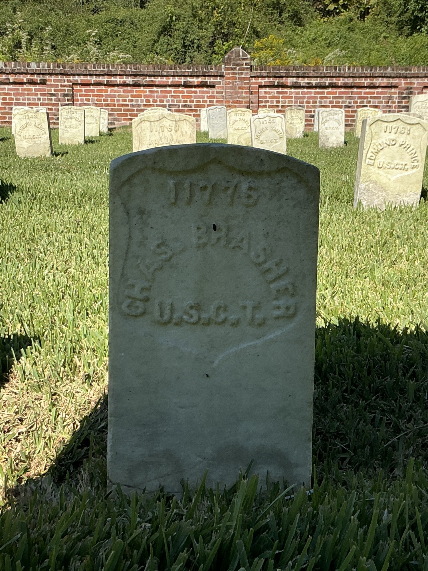 Front of historic upright marble headstone with recessed shield face.