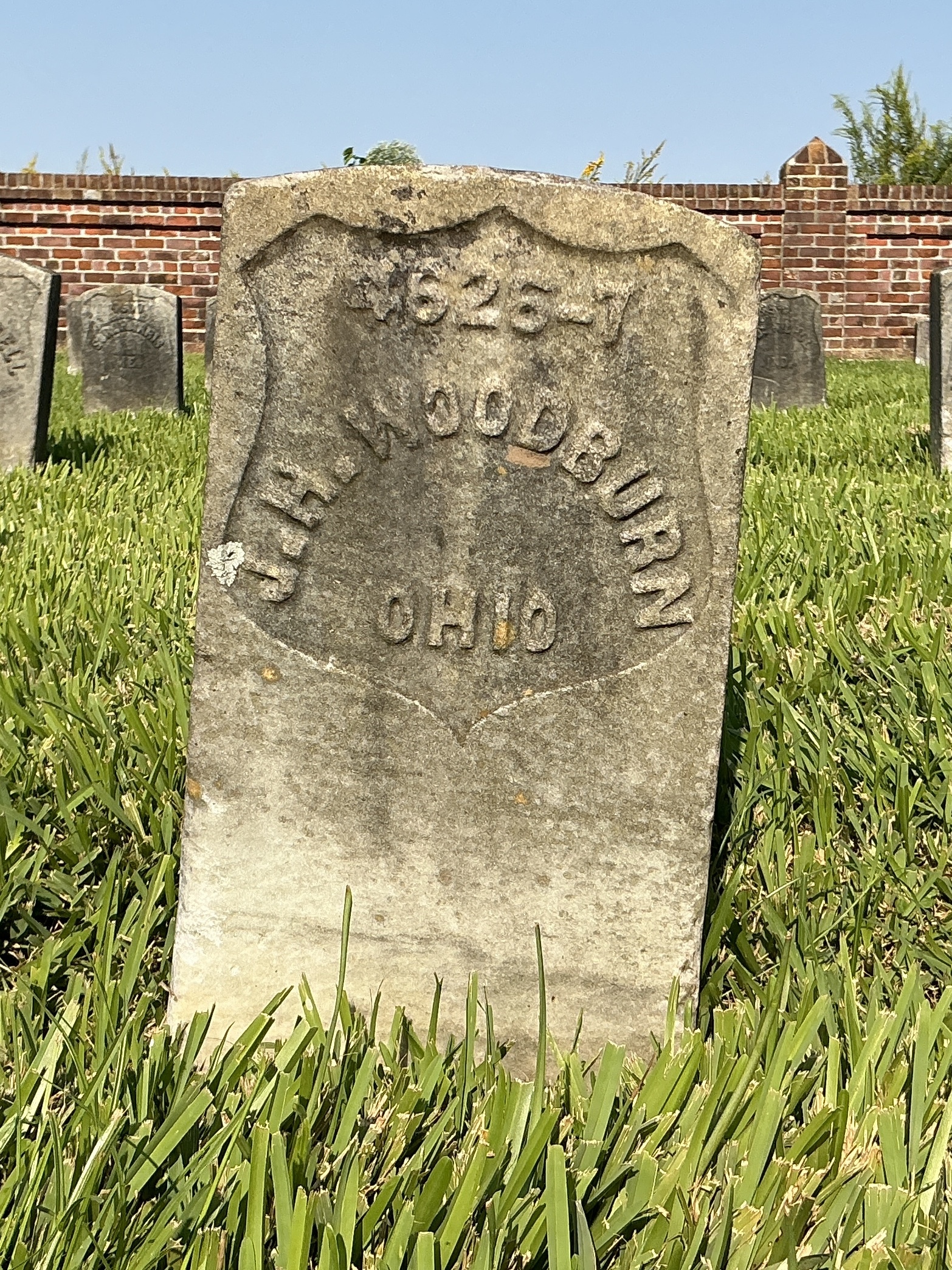 Front of historic upright marble headstone with recessed shield face.