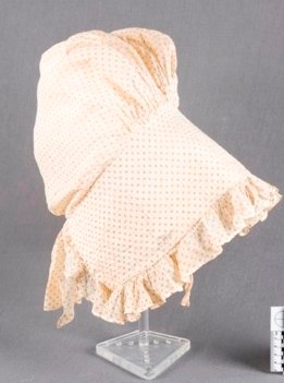 White sun bonnet decorated with small black circles.