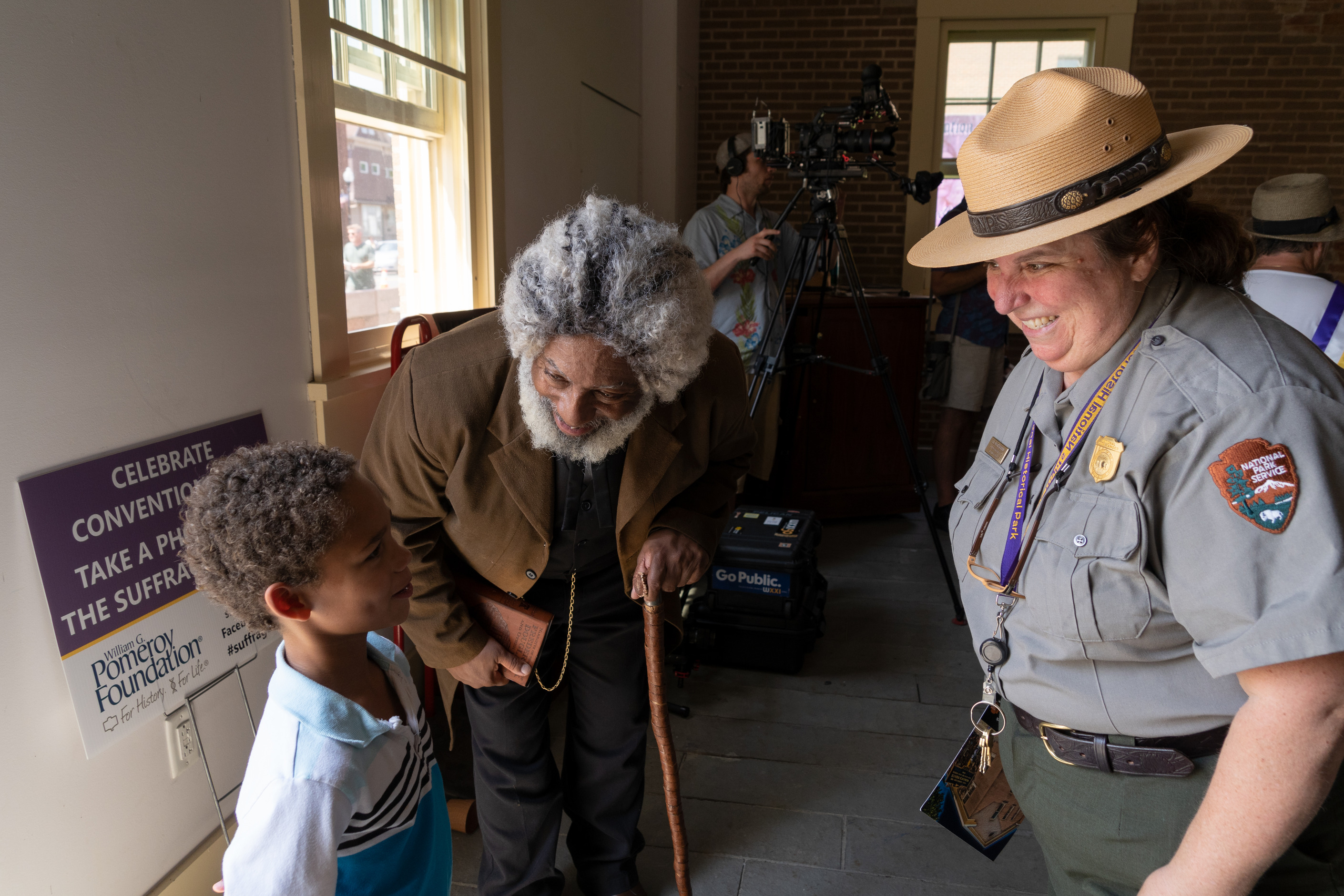 Frederick Douglass and a Park Ranger speak with a child.