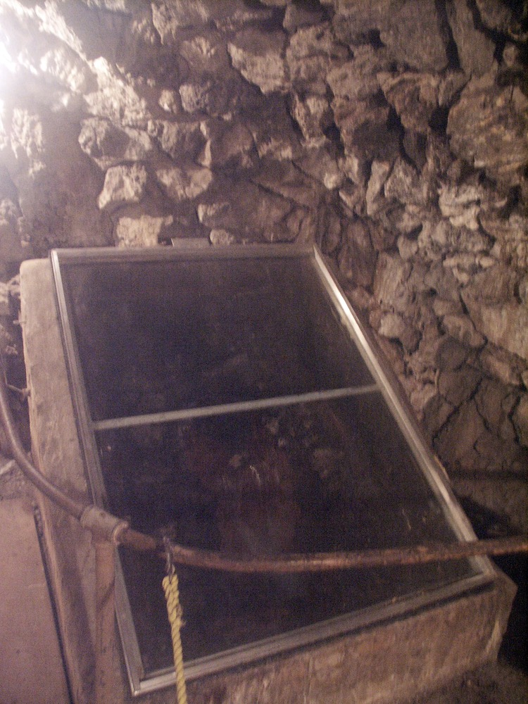 a raised box with slanted glass front in a room with rock walls