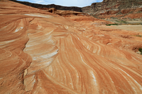 Photograph of cross-bedding in Jurassic Navajo Sandstone sand dunes. The cross beds are visible as bands of white, orange, and red layers that truncate each other.