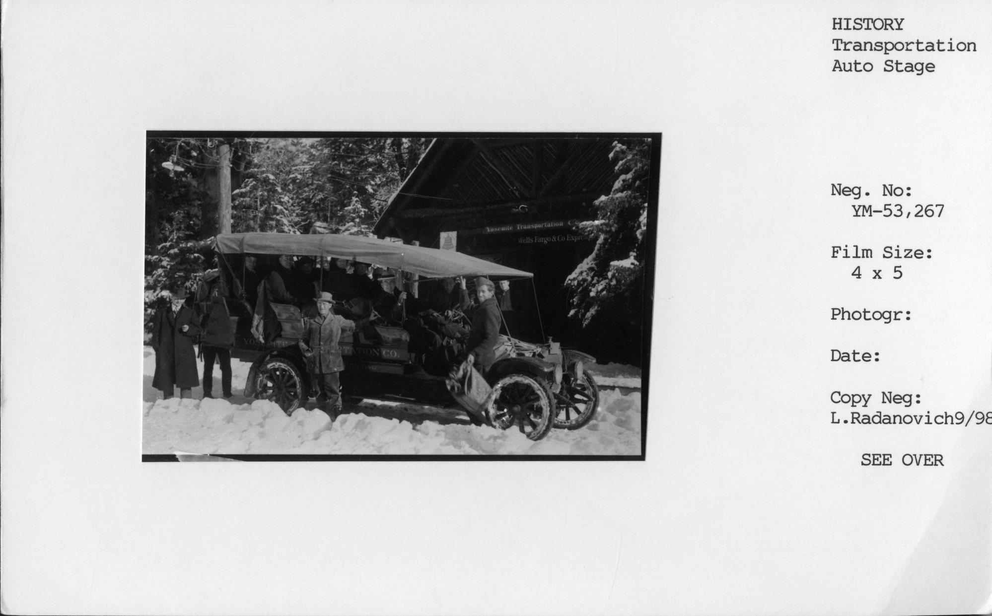 Copy Neg: Leroy Radanovich September 1998. Black and white postcard. Photograph shows Yosemite Transportation Co. auto-coach parked in front of the Wells Fargo/Yosemite Transporation Co. Office.