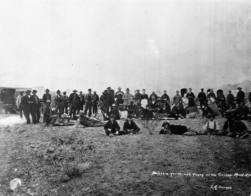 Brigham Young (with high hat in center) and large group of men and women. Caption on image: Brigham Young and party en route to the Colorado, March 19870, C.R. Savage.