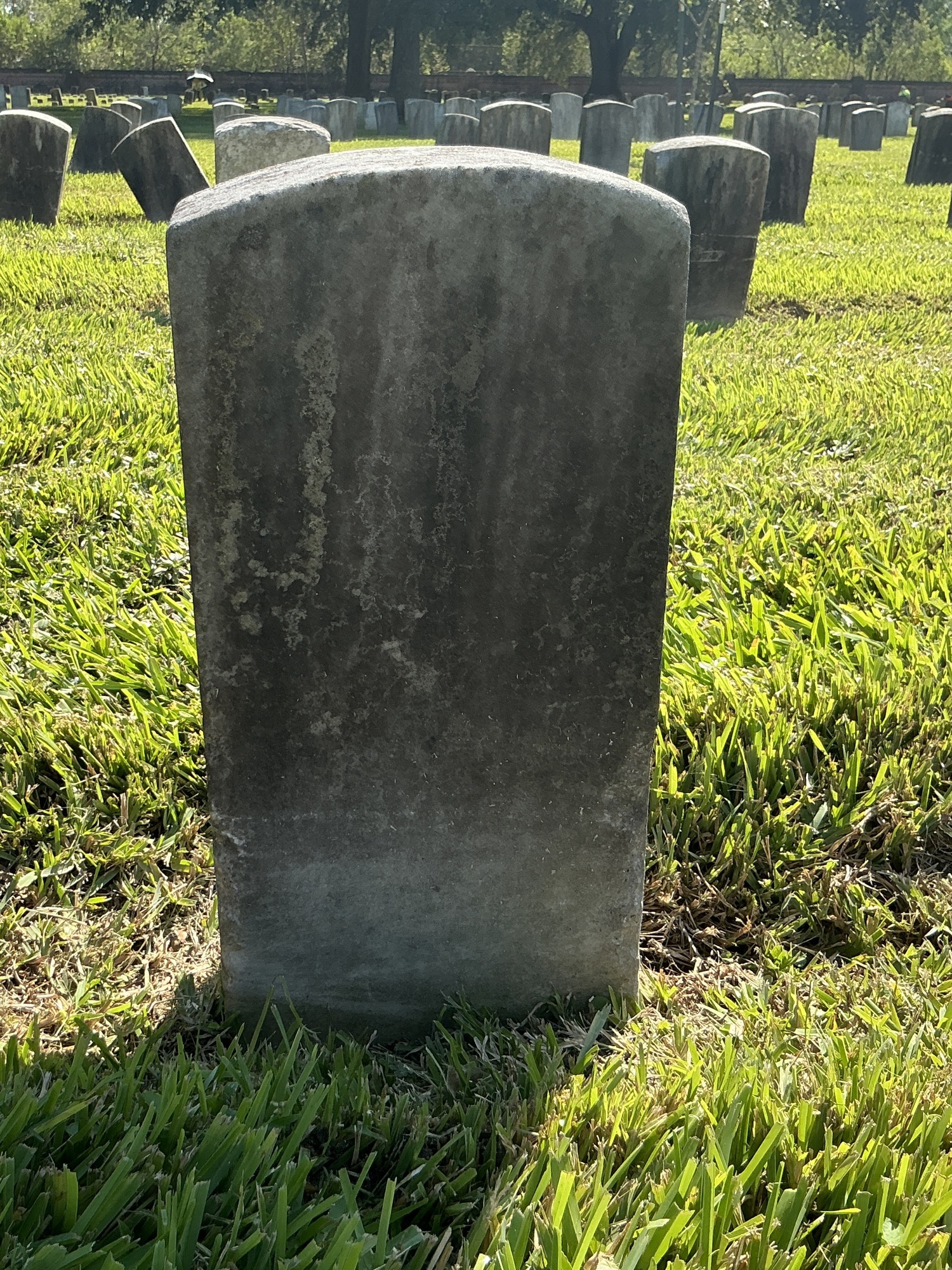 Back of historic upright marble headstone with recessed shield face.