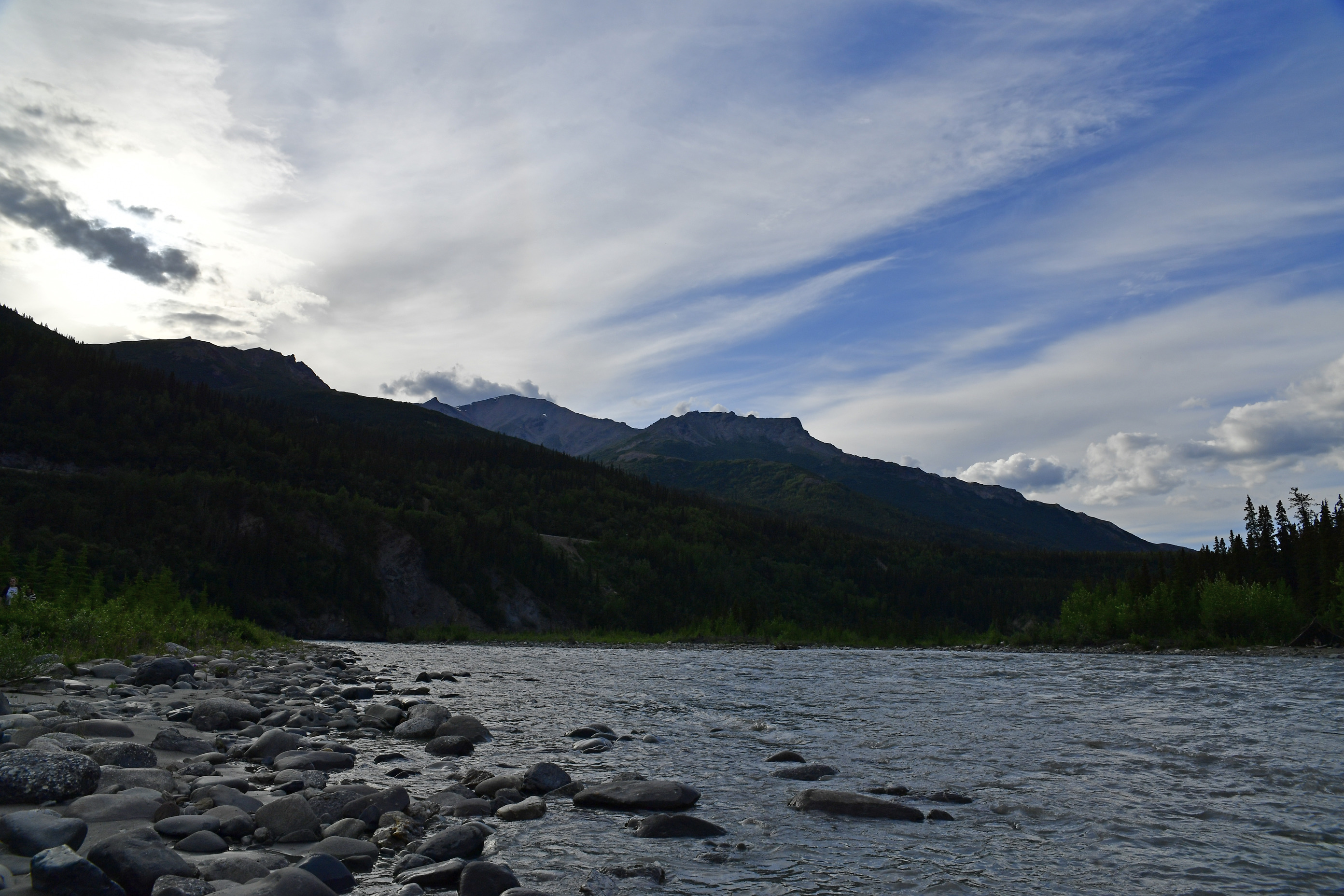 a large river bordered by forested hills