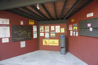Three Red walls come together. On the walls there are many pieces of colorful paper with information about the parks. 