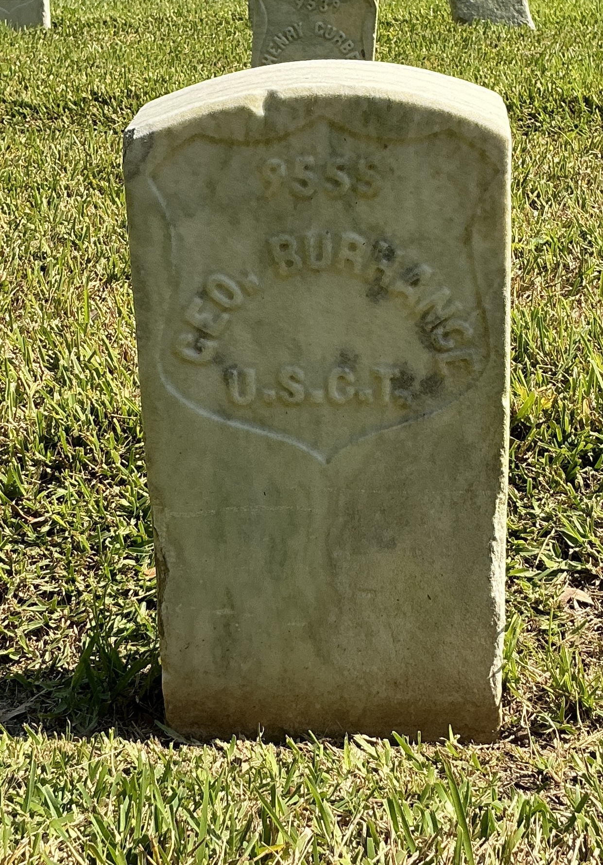 Front of historic upright marble headstone with recessed shield face.