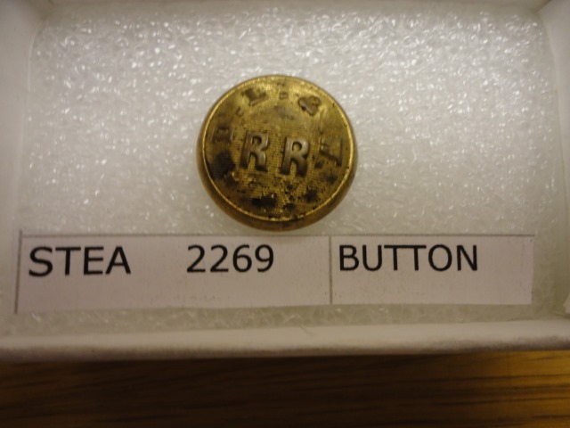 Button. Conductor. Obverse: gilded. Domed. Raised rim, corrugated field. Embossed "D.L.& W." in an arc; beneath is "RR" and 3 stars.