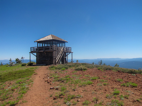 A two-story fire lookout on top a mountain top.