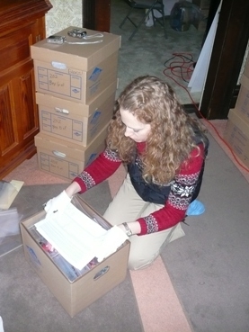 Curatorial staff member packs the artifacts contained in Bess Truman's desk in the second floor hallway.