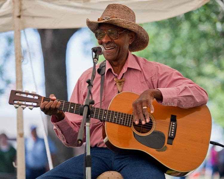 A man singing playing a guitar. 