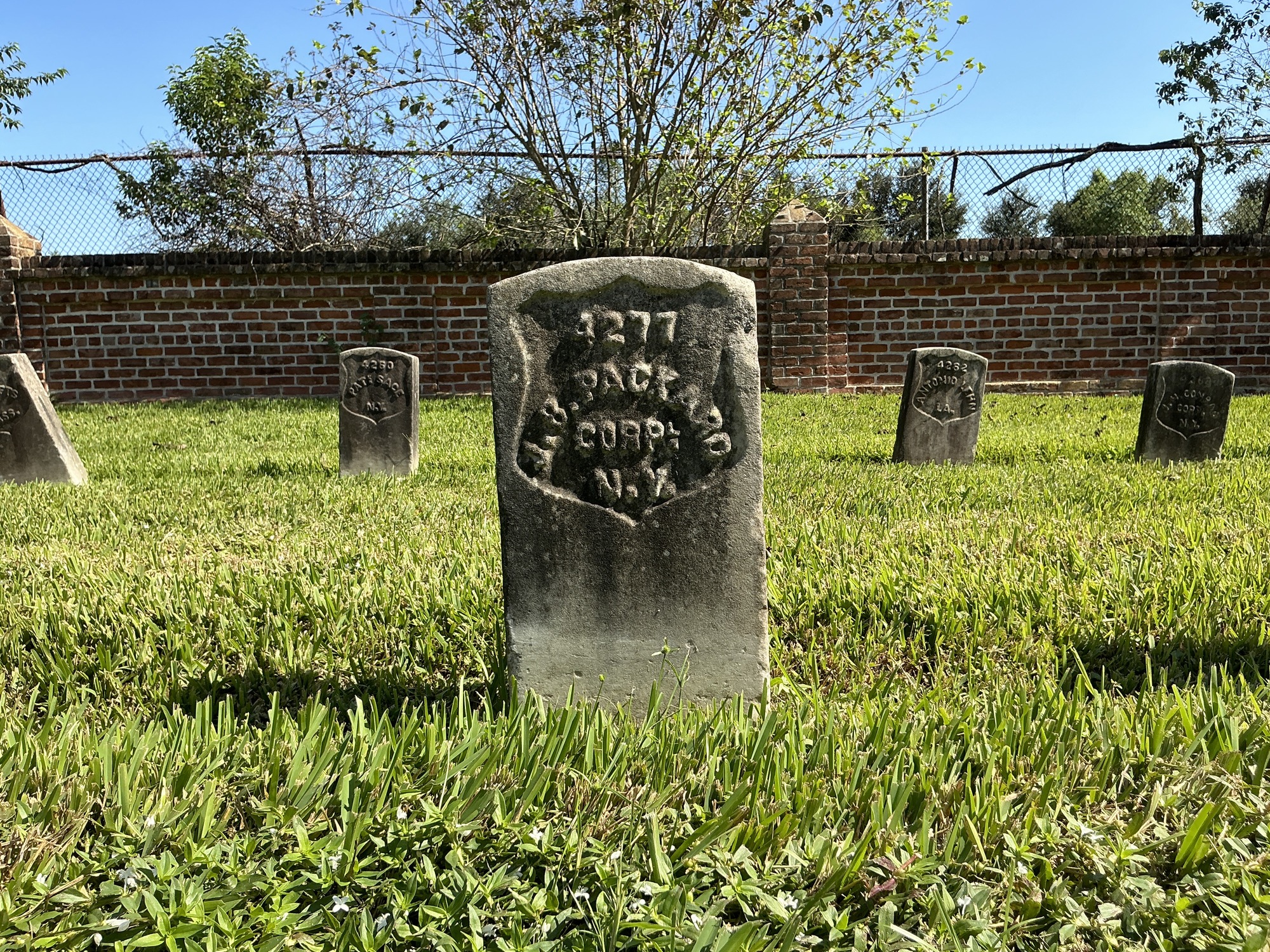 Front of historic upright marble headstone with recessed shield face.