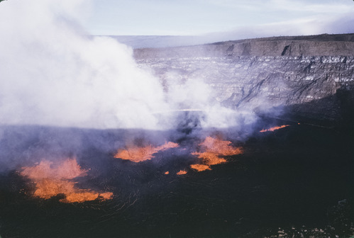 Lava fountains and steam clouds on the floor of a volcanic crater