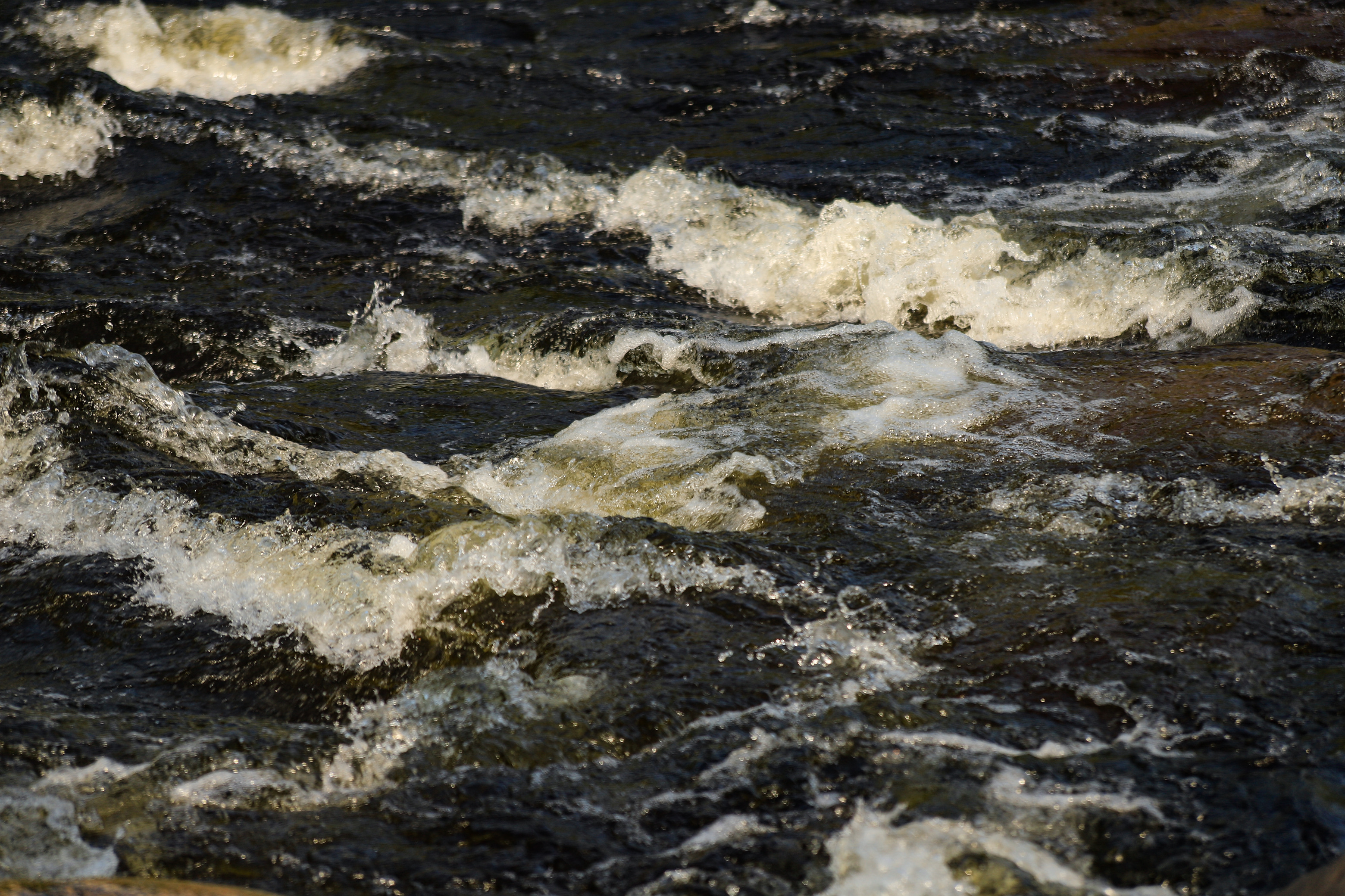 Close up of small waves of white water in a stream