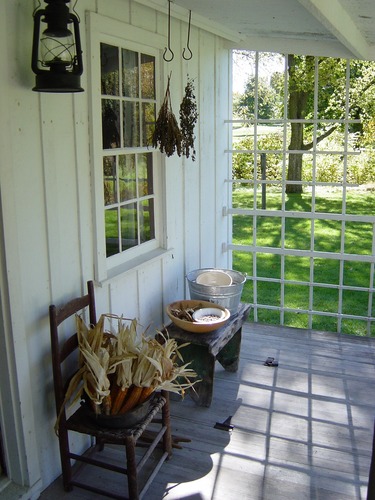 Hanging herbs and corn adorn the back porch of the Birthplace Cottage.