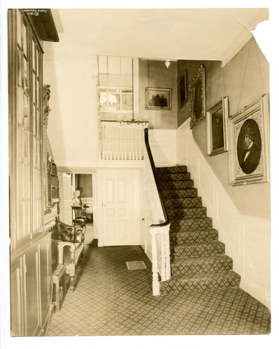 Staircase with portraits hanging along the wall.