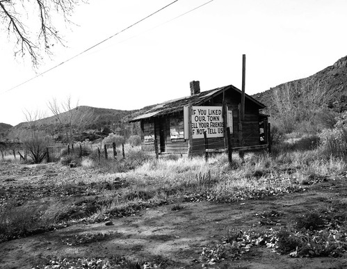 Roadside signs in Springdale, obsolete signs. Image is of an old building with sign on side 'If you like our town tell your friends, if not tell us.'