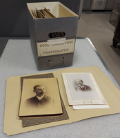 2 historical photos rest in front of a file box labeled, 