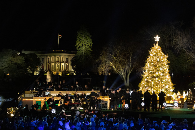 A large lit up Christmas tree with the White House behind it. 