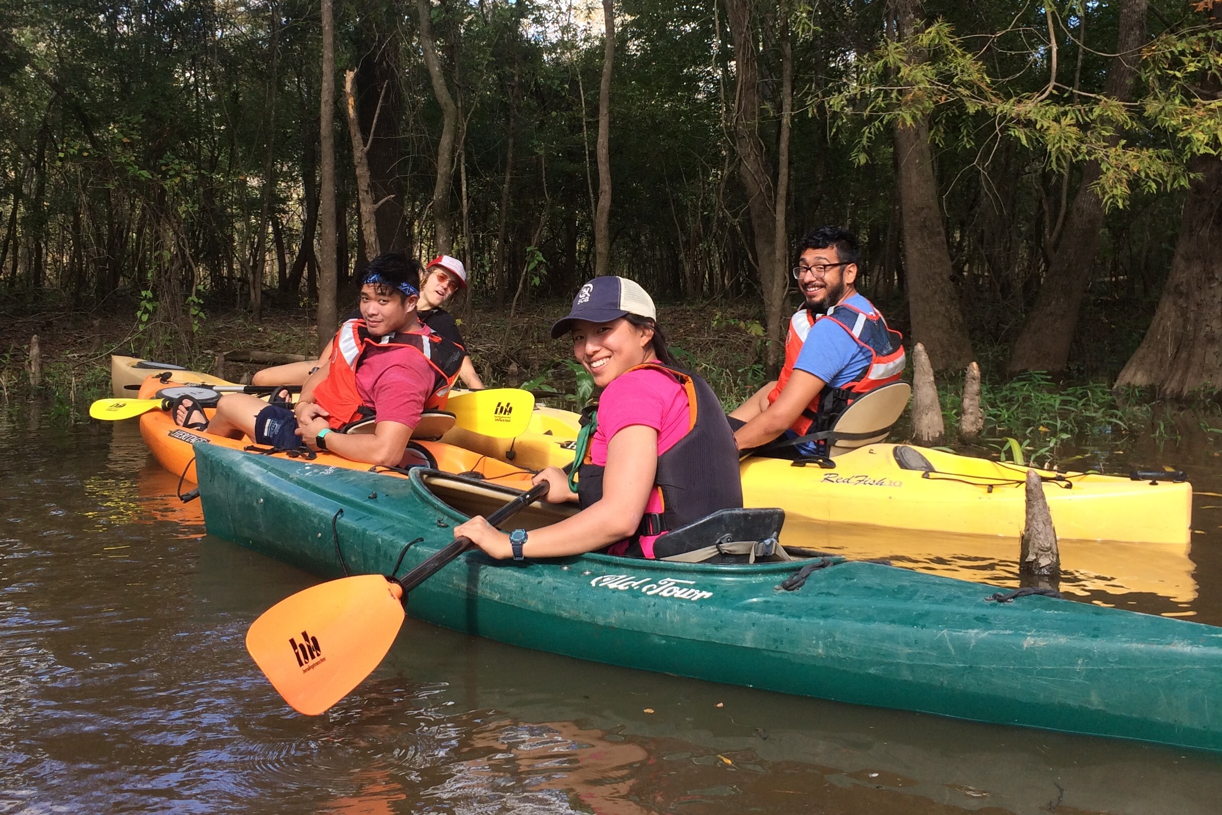 a group of young people with colorful kayaks