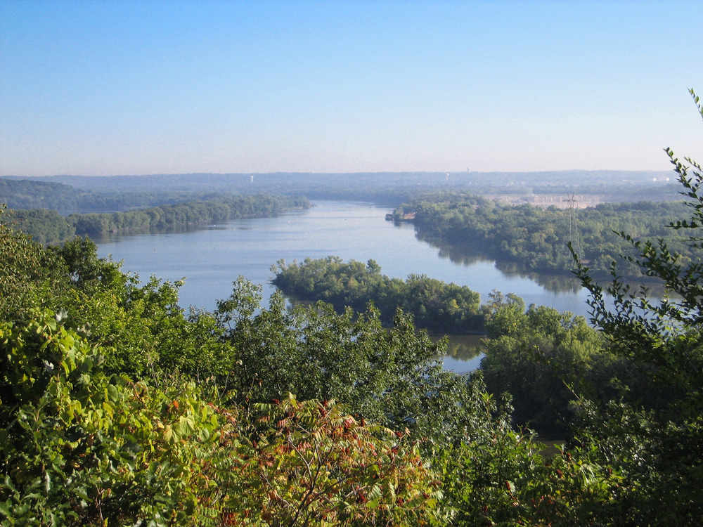 A large river winds its way among forested hills.