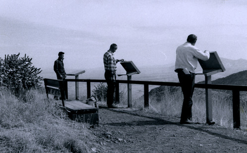 Three individuals look at wayside exhibits