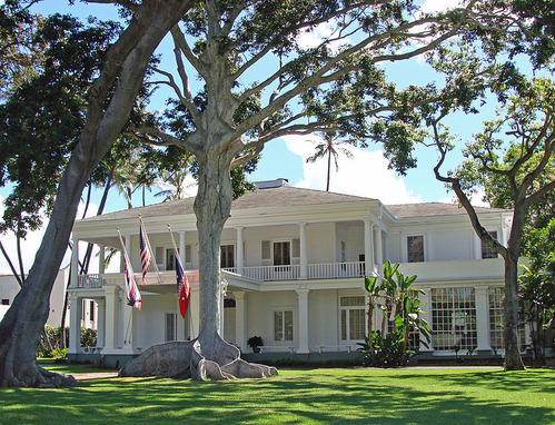 Exterior of the front of Washington Place with lawn and palm trees