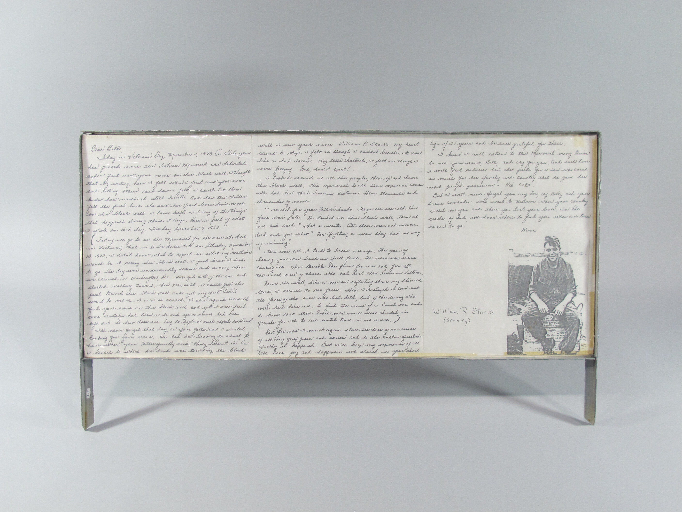 Letter written by Eleanor Wimbish to her son, William Reed Stocks (KIA 02/13/1969) on November 11, 1983. In it, she recalls her first visit to the Wall, on November 9, 1982, and records what her diary entry from that day said. Written on three pages that have been mounted side-by-side on cardboard wrapped with tissue paper, and then wrapped with plastic and placed in a metal frame with three legs.
