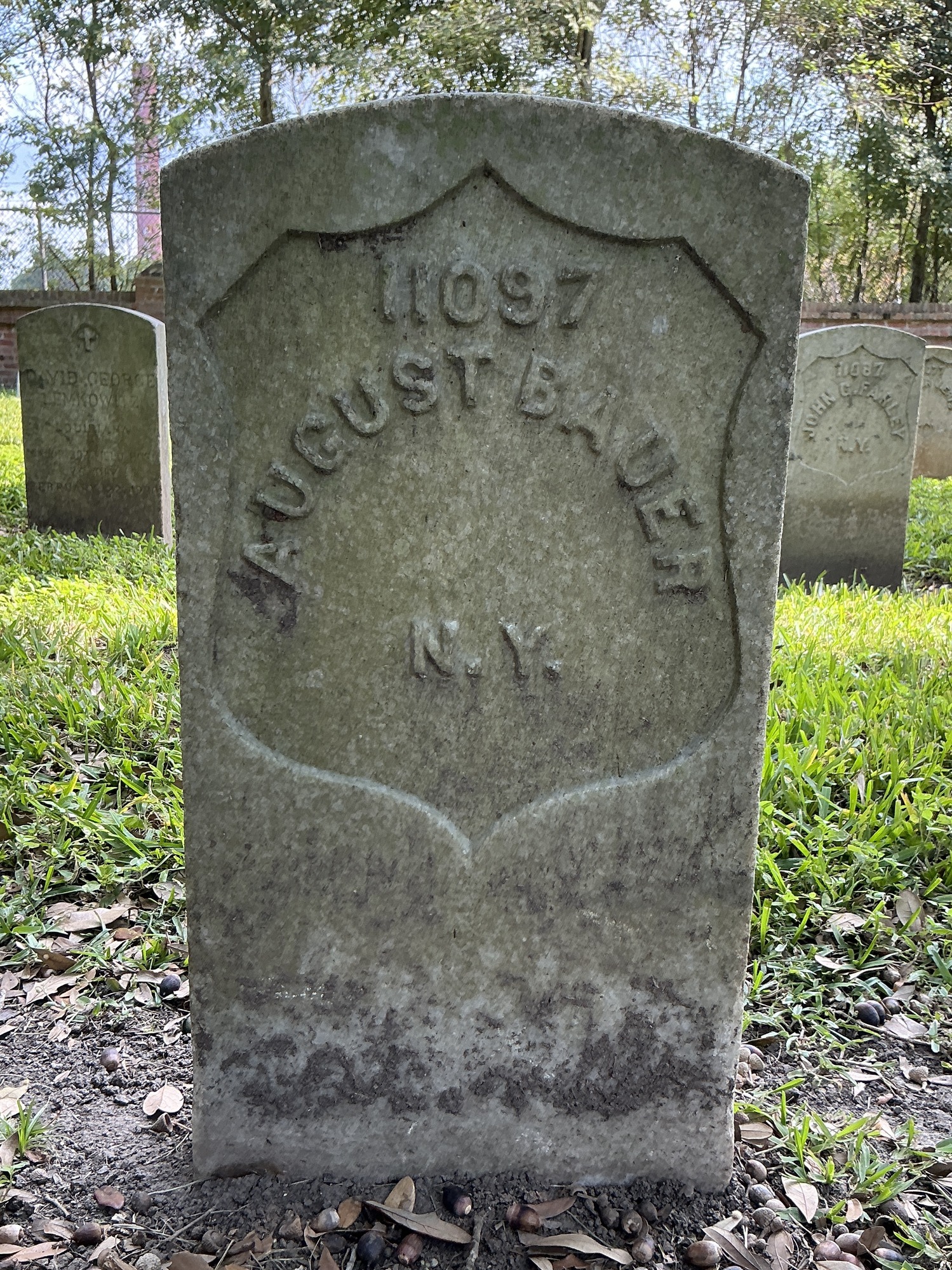 Front of historic upright marble headstone with recessed shield face.