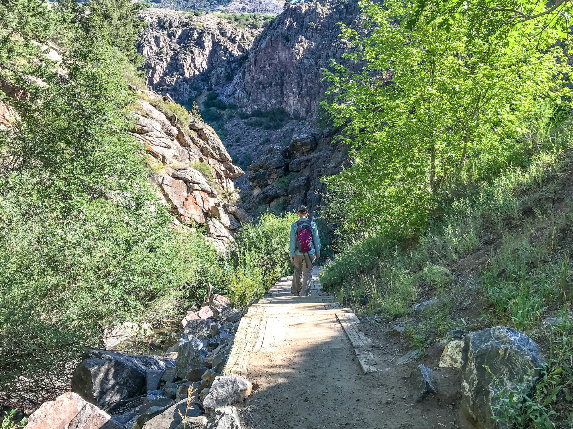 Person hiking on a trail down a canyon