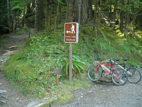 Bikes parked at a trailhead with a sign reading "Green Lake trailhead."