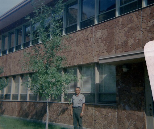 Man standing next to the headquarters building during the construction of headquarters addition.
