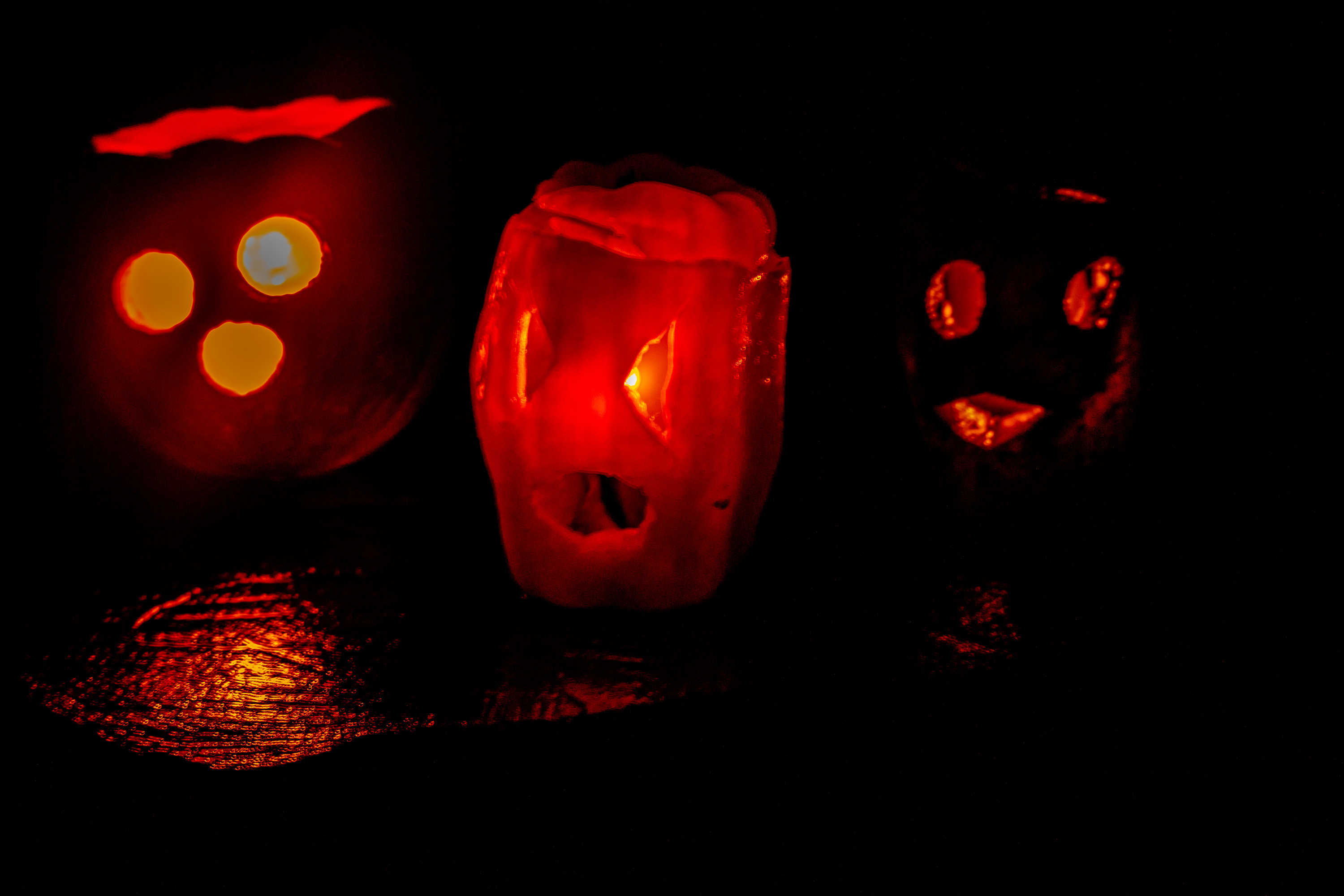 Three carved pumpkins lit from within