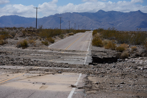 Washed over road with missing portions of asphalt.