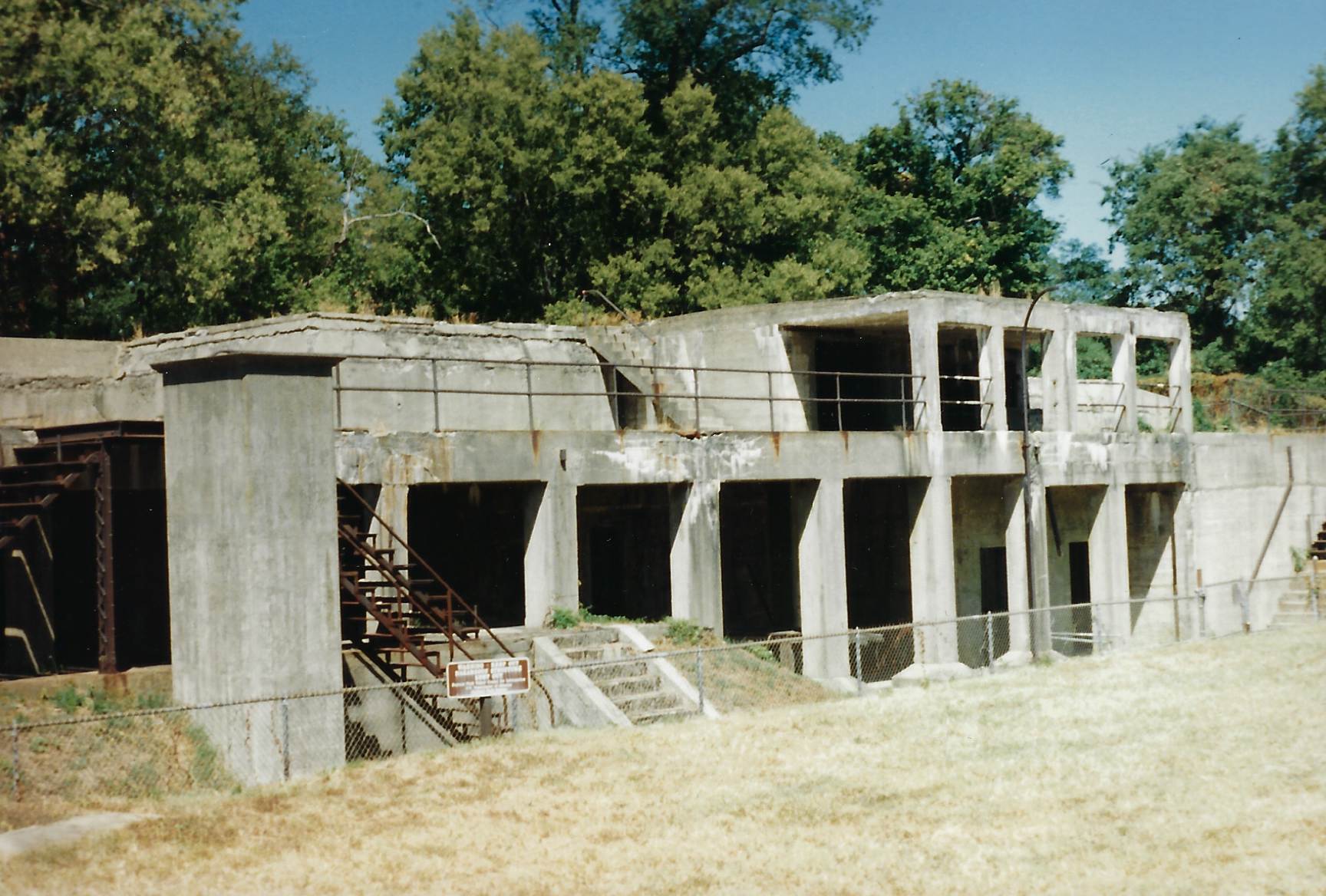Photo of concrete and steel gun battery, two levels with steel and concrete steps.  
