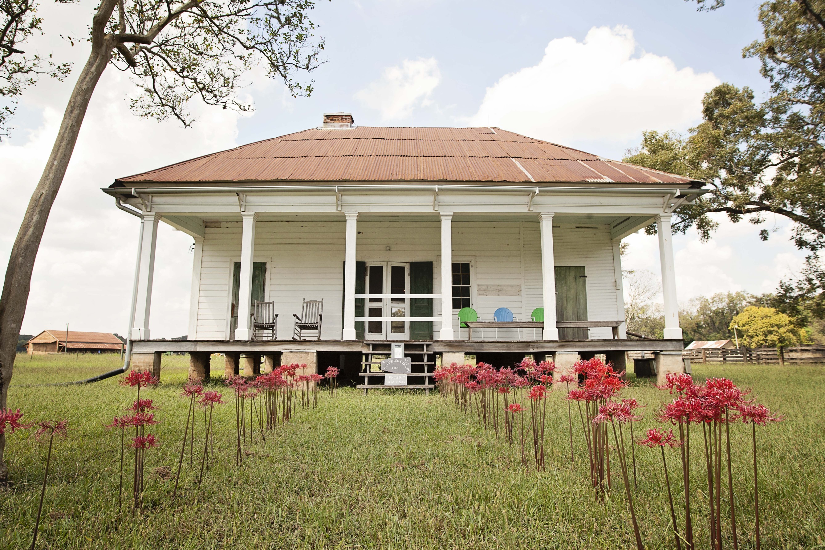 The front of the Overseer's house . You know its fall when the Spider Lillie's bloom. Red spider lilies line the pathway to the front porch. 