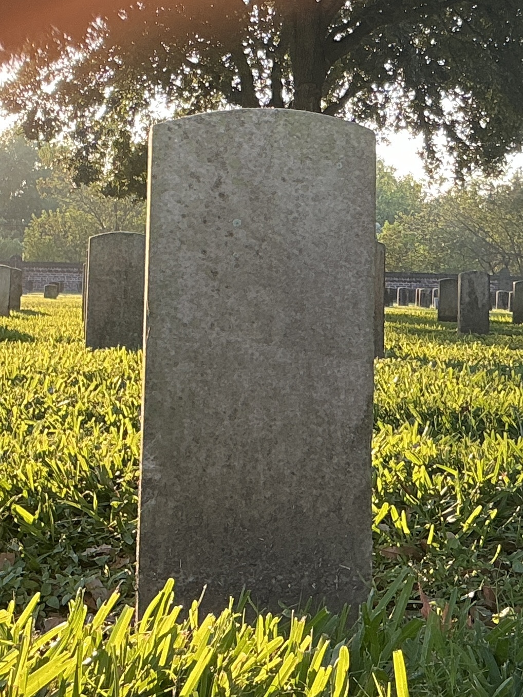 Back of historic upright marble headstone with recessed shield face.