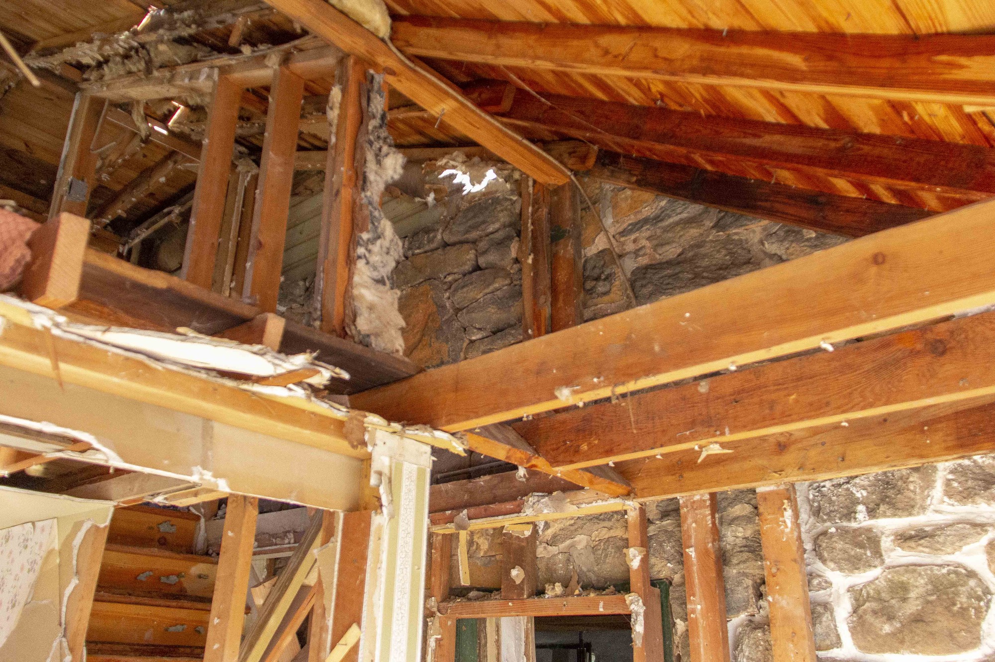 Preservationists continue to restore the inside of the house to its original structure through the selective demolition process. The wall and ceiling plaster has been removed to reveal the original stone structure of the house. 