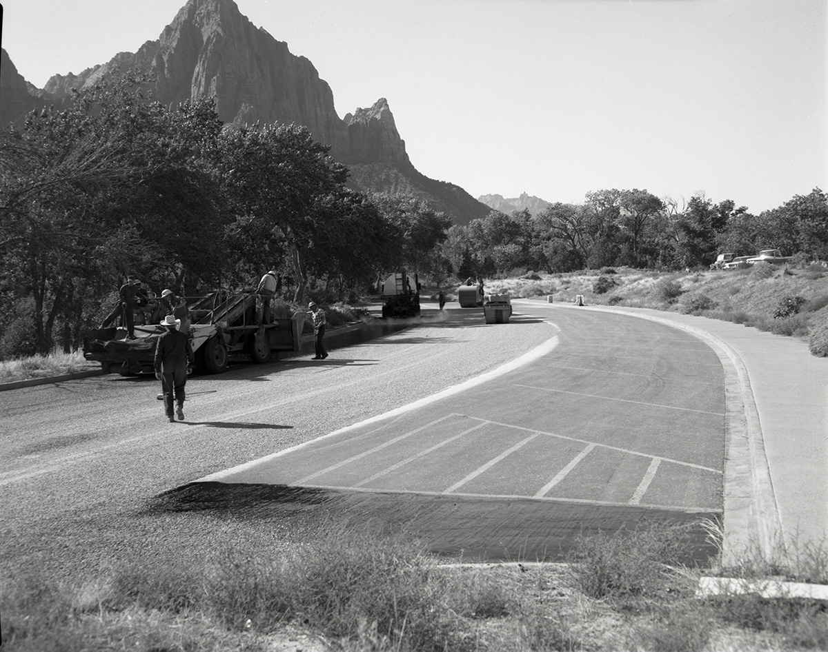 Men operating sealcoating machine while sealcoating parking area in Zion.
