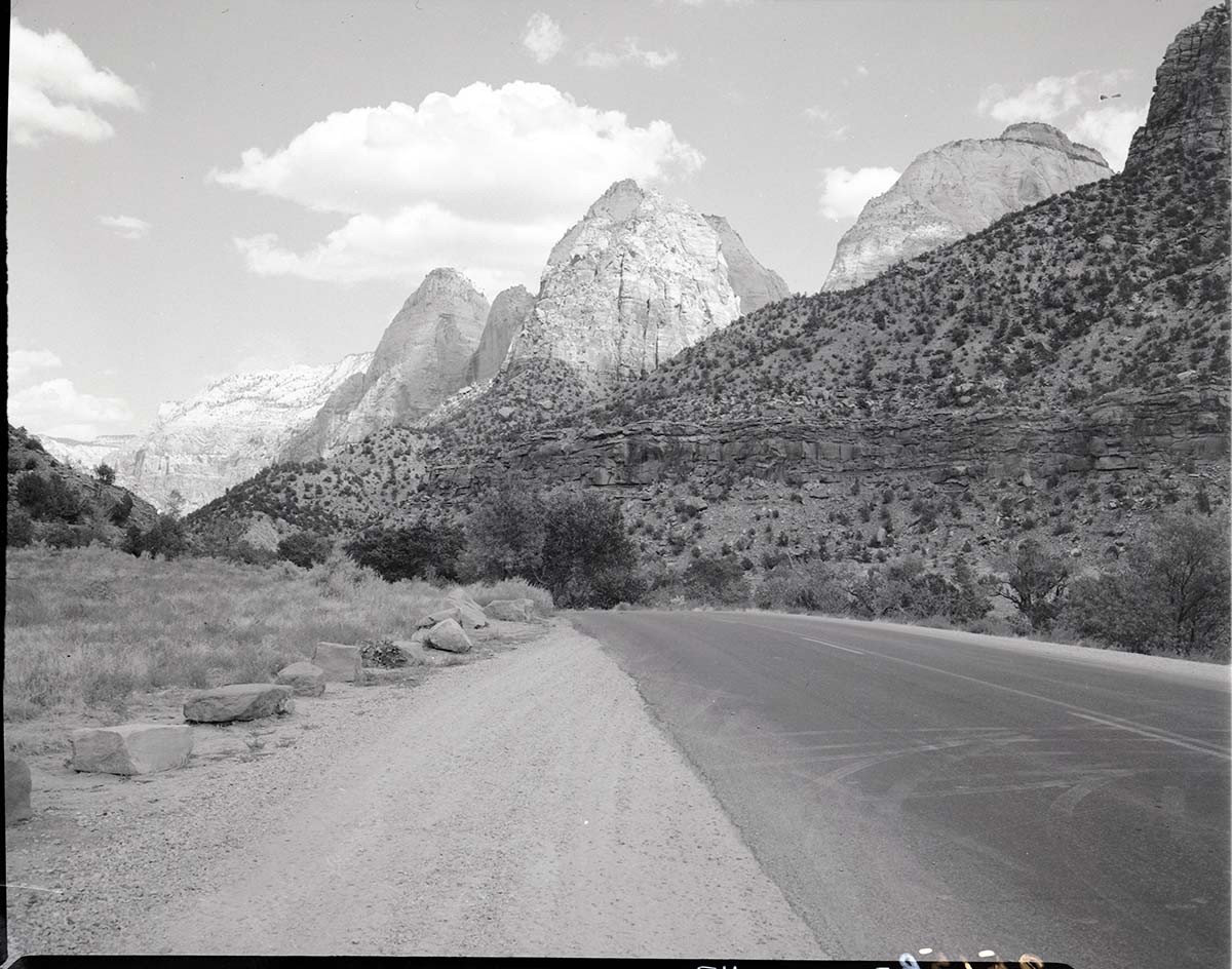 Proposed site for new Mission 66 Visitor Center and Museum, view northeast. From right to left: East Temple, Mount Spry, Twin Brothers, and Mountain of the Sun.