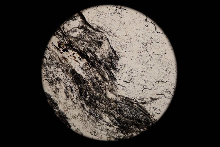 Circular microscopic image of rock structure.