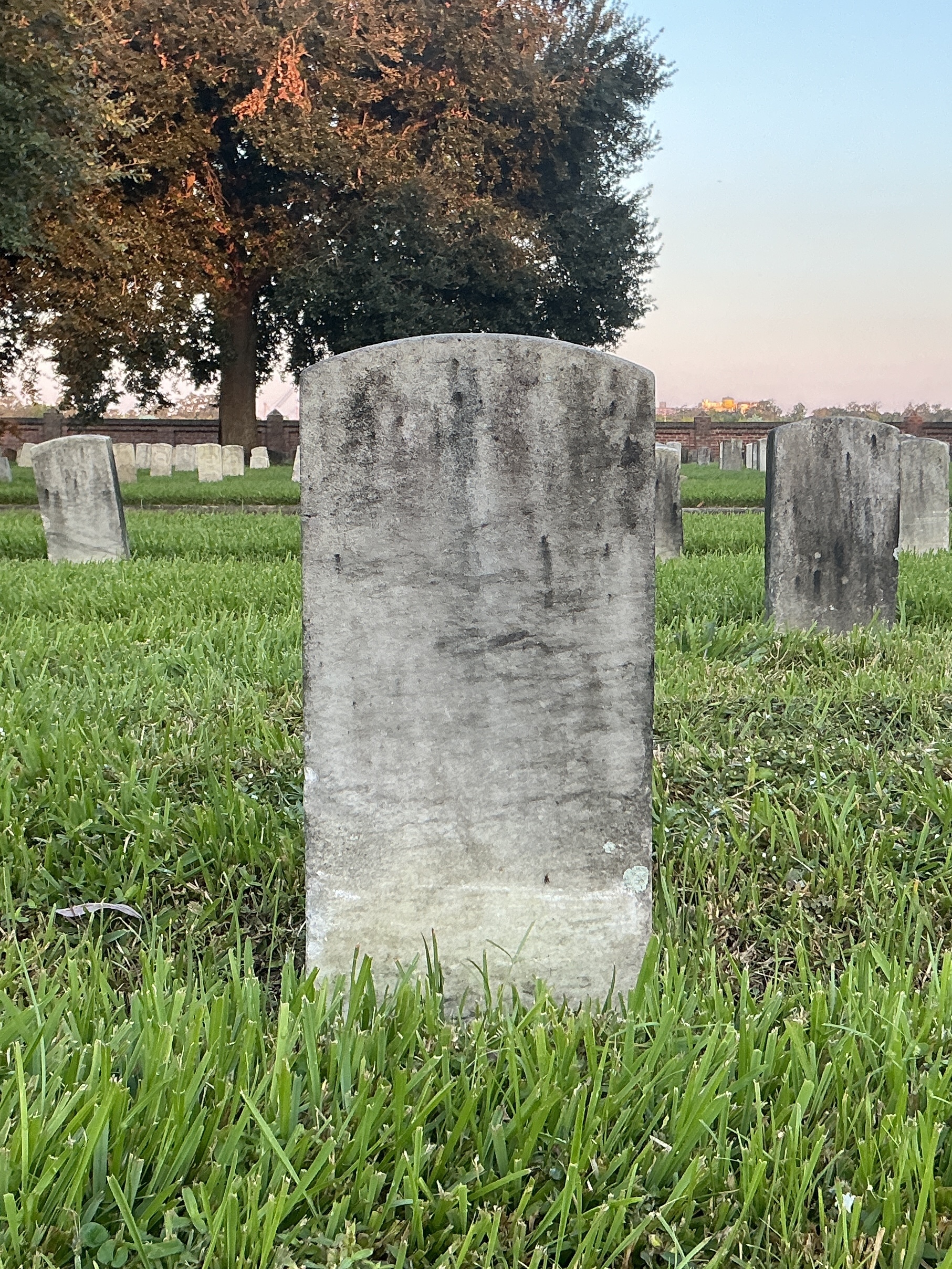 Back of historic upright marble headstone with recessed shield face.