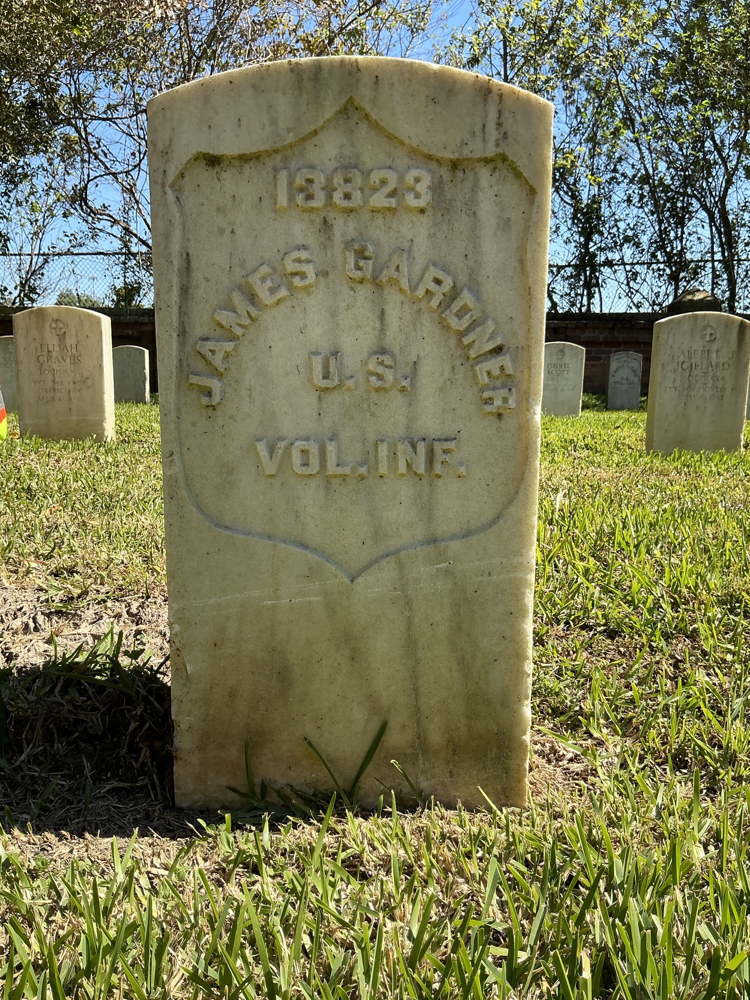 Front of historic upright marble headstone with recessed shield face.