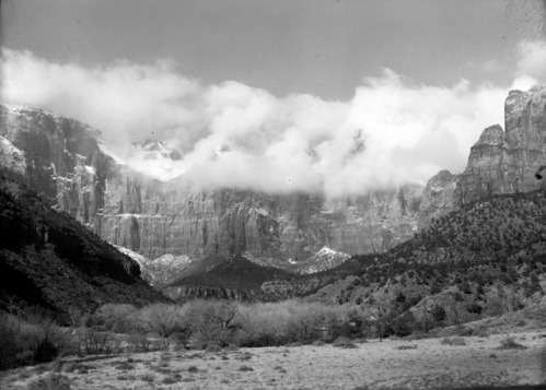 The West Temple and Towers of the Virgin shrouded in clouds and snow, Oak Creek residences in foreground.