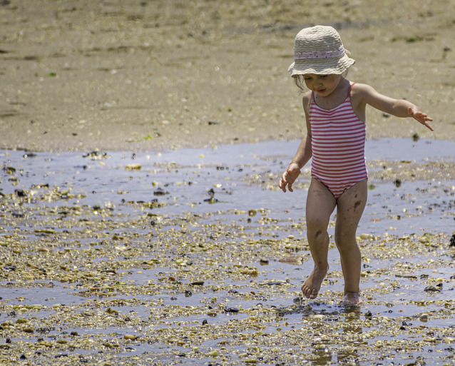 young girl walking on shore at Sandy Hook