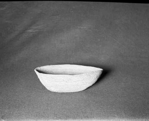 Mrs. Geraldine McConnel Collection. Object: Miwok basket. Dimensions: 9 1/2" x 3". Materials: Scrapped shoots, split bull pine branchlets. Technology: Single rod: interlocking stitch, clockspring start. Heavy repair on each side in the same material. Collection History: From a member of Mrs. McConnell's family that lived in Sonora. Thought to have been acquired from a Miwok woman in Sonora probably c. 1900. Photographed by Michael Dixon in January 1983. Catalogued by Craig Bates and Barbara Beroza. Yosemite Collections, National Park Service.
