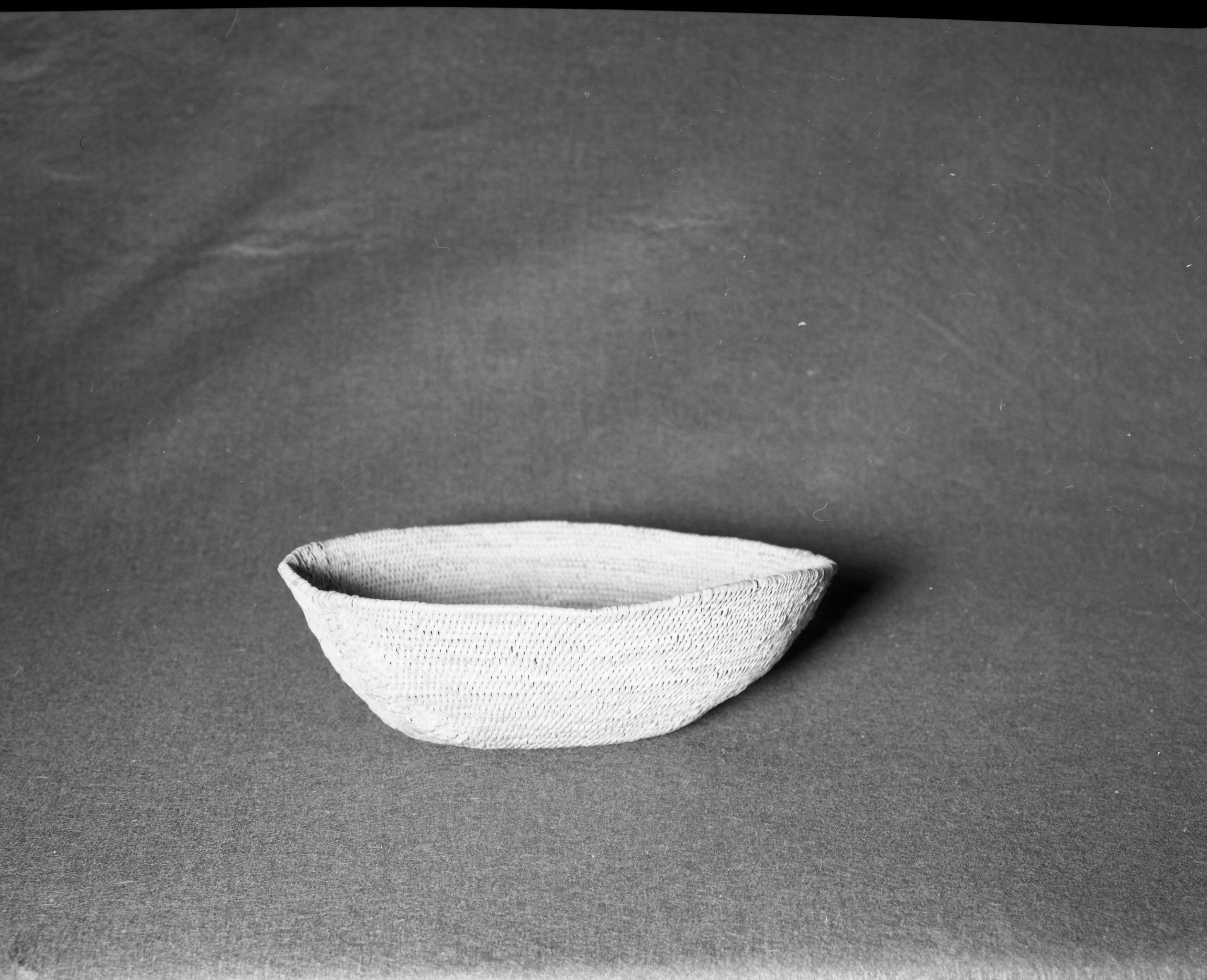 Mrs. Geraldine McConnel Collection. Object: Miwok basket. Dimensions: 9 1/2" x 3". Materials: Scrapped shoots, split bull pine branchlets. Technology: Single rod: interlocking stitch, clockspring start. Heavy repair on each side in the same material. Collection History: From a member of Mrs. McConnell's family that lived in Sonora. Thought to have been acquired from a Miwok woman in Sonora probably c. 1900. Photographed by Michael Dixon in January 1983. Catalogued by Craig Bates and Barbara Beroza. Yosemite Collections, National Park Service.