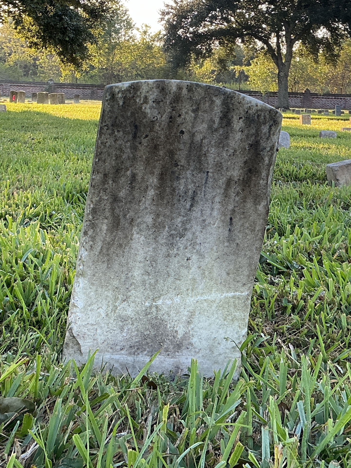 Back of historic upright marble headstone with flat face.